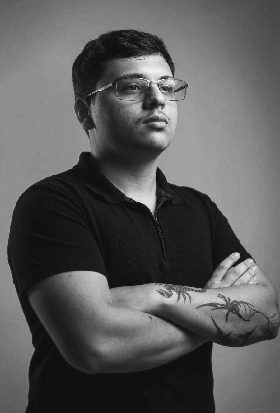 Retrato em preto e branco de um integrante da SKIP, de braços cruzados.